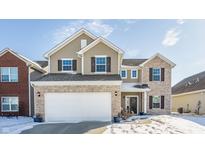 Charming two-story home with brick and vinyl siding and a two-car garage, all with a beautiful blue sky at 5303 Brandywine Dr, Whitestown, IN 46075