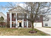 Stunning two-story brick home features a large, covered front porch with stately white columns at 5815 Noble Dr, Indianapolis, IN 46234