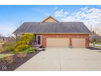 Charming brick home with a two-car garage and mature landscaping on a sunny day at 6045 Channel Dr, Columbus, IN 47201