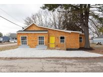 Charming one-story home with a yellow door, wood siding, and a well-maintained front yard at 650 S Lyons Ave, Indianapolis, IN 46241