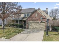 Charming two-story home featuring a brick facade, attached two-car garage and a well-manicured front lawn at 7304 Hardin Oak Dr, Noblesville, IN 46062