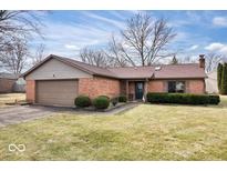 Charming brick home with an attached garage, manicured landscaping, and a well-maintained lawn at 7326 Caboose Ct, Indianapolis, IN 46256