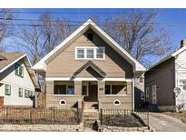 Charming two-story home featuring unique architectural details and a well-maintained front yard with wrought iron fence at 764 E 42Nd St, Indianapolis, IN 46205