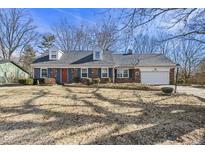 Charming brick home with dormers, a red door, attached garage, and a well-maintained front yard at 8121 S East St, Indianapolis, IN 46227