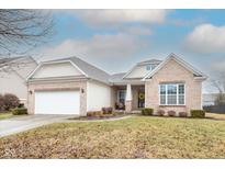 Charming brick home with an attached two-car garage and a manicured front lawn at 8623 New Heritage Dr, Indianapolis, IN 46239