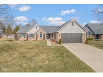 Charming single-Gathering home featuring a brick facade, well-kept lawn, and a two-car attached garage at 9046 Pinecreek Ct, Indianapolis, IN 46256