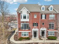 Charming brick townhome featuring a balcony and manicured landscaping at 1072 3Rd Nw Ave, Carmel, IN 46032