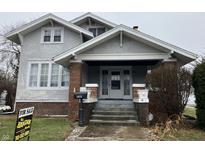 Charming two-story home featuring a covered front porch with brick accents and well-maintained landscaping at 2025 Main St, Elwood, IN 46036