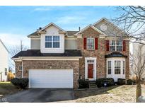 Charming two-story home with brick facade, attached garage, and well-manicured landscaping at 2261 Sandringham Cir, Indianapolis, IN 46214