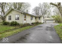 Charming single-story home with a detached garage and an asphalt driveway, perfect for suburban living at 3807 S Olney St, Indianapolis, IN 46237