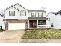 Charming two-story home with attached garage, front porch, well-maintained lawn, and eye-catching green shutters at 3822 Churchman Woods Blvd, Indianapolis, IN 46203