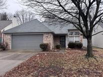 Charming single-story brick home featuring an attached garage and manicured landscaping at 5142 Aspen Talon Ct, Indianapolis, IN 46254