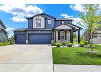 Beautiful two-story home featuring a three car garage, manicured lawn, and attractive blue and gray exterior at 5461 Oak Knoll Dr, Whitestown, IN 46075