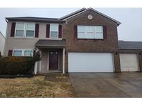 Two-story home with a brick and vinyl facade, attached two-car garage, and manicured front lawn at 705 Breakers Ln, Fortville, IN 46040