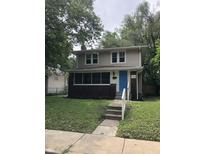 Charming two-story home featuring a blue front door and a brick foundation at 749 W 32Nd St, Indianapolis, IN 46208