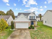 Charming two-story home features a brick facade, two-car garage, and well-manicured lawn at 8325 Flicker Ct, Indianapolis, IN 46237