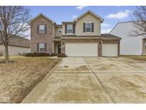 Inviting two-story home with brick and siding, a well-manicured lawn, and a convenient two-car garage at 8547 S Tibbs Ave, Indianapolis, IN 46217