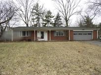 Charming brick ranch-style home featuring an attached garage and covered entryway at 9150 Granville Ct, Indianapolis, IN 46229
