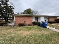 Cozy brick home featuring manicured landscaping, creating an inviting curb appeal at 931 W Mckay Rd, Shelbyville, IN 46176