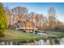 Stunning waterfront home with expansive deck overlooking a serene lake and lush greenery at 10128 S 700 W, Columbus, IN 47201
