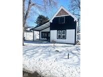 Striking black and white two-story home featuring a covered porch and updated exterior at 12003 Broadway St, Indianapolis, IN 46236