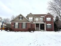 Attractive two-story brick home with a welcoming front porch and snow-covered yard at 14596 Toponas Pl, Fishers, IN 46040