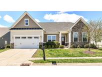 Charming single-Gathering home features a well-manicured lawn and an attached two-car garage at 2564 Tangleridge Ln, Brownsburg, IN 46112