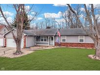 Charming ranch-style home features a well-manicured lawn, inviting front porch, and a two-car attached garage at 3694 Creekwood Dr, Greenwood, IN 46142