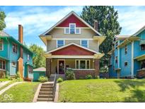Charming two-story home with red and tan siding, brick-lined porch, and inviting curb appeal at 4029 Broadway St, Indianapolis, IN 46205