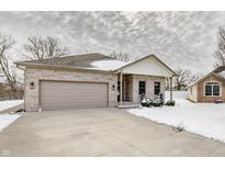 Charming brick home with a two-car garage and cozy front porch in a winter setting at 4252 Wellington Ct, Columbus, IN 47201