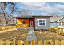 Charming single-story home features a mix of siding and a lovely front porch, surrounded by a cute picket fence at 4804 Brouse Ave, Indianapolis, IN 46205