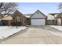 Charming brick home featuring an attached garage and a well-maintained front yard at 4911 Wisteria Dr, Indianapolis, IN 46254