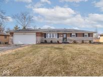 Charming brick and stone home featuring an attached garage and well-maintained lawn at 5312 Daniel Dr, Indianapolis, IN 46226