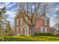 Charming two-story brick home with mature trees and a well-manicured lawn on a partly cloudy day at 5752 River Rd, Waldron, IN 46182