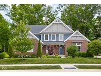 Charming two-story brick home with lush landscaping and inviting front porch at 6504 W May Apple Dr, McCordsville, IN 46055