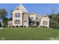 Charming two-story home featuring a stone facade, wood accents, and a well-manicured lawn at 14335 Stella Ct, Fishers, IN 46040
