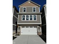 Two story home with a grey exterior, white garage door and trim, and black carriage style hardware at 15405 Mystic Rock Dr, Carmel, IN 46033