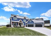 Charming two-story home featuring a three-car garage and a welcoming front porch at 20451 Chatham Hills Blvd, Westfield, IN 46074