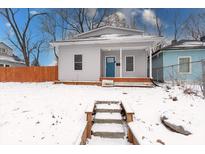 Charming home featuring a quaint covered porch and a welcoming blue front door at 2639 E Brookside Ave, Indianapolis, IN 46218