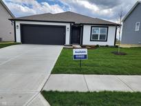 Charming single-story home featuring a black garage door, white siding, and an 