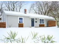 Charming home exterior with horizontal siding, trimmed windows, front door wreath, and snow-covered yard at 3415 N Wittfield St, Indianapolis, IN 46235