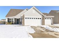 Charming single-story home featuring a two-car garage and inviting curb appeal on a snow-covered lawn at 5713 Anders Ln, Indianapolis, IN 46235