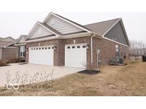Brick home features attached two car garage, concrete drive, and well manicured lawn at 7349 Doyal Dr, Whitestown, IN 46075