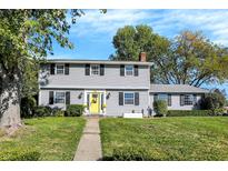 Charming two-story home with light gray siding, black shutters, and a bright yellow front door at 908 Whispering Trl, Greenfield, IN 46140