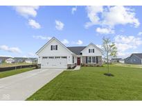 Beautiful exterior of a home featuring a white facade, stone accents, well-manicured lawn, and a two-car garage at 1202 Brightwood Cir, Greenfield, IN 46140