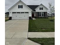 Charming two-story home featuring a two-car garage, a red door, and a well-manicured lawn at 1202 Brightwood Cir, Greenfield, IN 46140