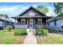 Charming home featuring a covered front porch, stone exterior, and well-maintained landscaping at 1933 Koehne St, Indianapolis, IN 46202