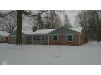 Charming single-story brick home with gray accents and snow-covered yard and roof at 3121 W 13Th St, Anderson, IN 46011