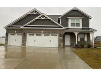 Charming two-story home with a three-car garage, brick facade and stylish gable decorations at 3197 S Hume Rd, New Palestine, IN 46163