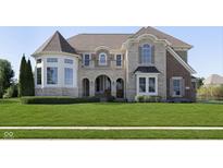 Inviting stone and brick exterior featuring a turret, arched entryway, balcony, lush lawn and manicured landscaping at 3236 Willow Bend Trl, Zionsville, IN 46077